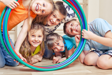 Children smiling through Hula Hoop